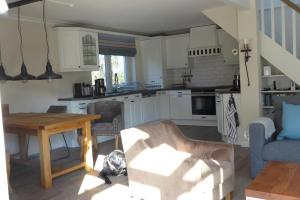 ein Wohnzimmer mit Tisch und Küche in der Unterkunft Sonnenschein 9184 - Neujellingsdorf in Neujellingsdorf