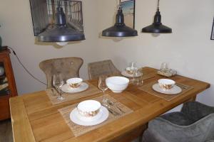 ein Holztisch mit Tellern und Gläsern darauf in der Unterkunft Sonnenschein 9184 - Neujellingsdorf in Neujellingsdorf