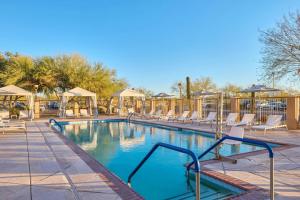 a swimming pool with a bunch of chairs around it at Residence Inn Phoenix Desert View at Mayo Clinic in Phoenix