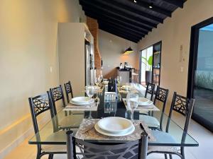 a dining room with a glass table and chairs at 2 Suítes Novas Alto padrão Área de Lazer Ampla in Foz do Iguaçu