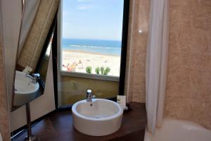 a bathroom with a sink and a view of a beach at AmbientHotels Panoramic in Rimini
