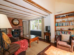 un salon avec un canapé et une table dans l'établissement Gun Hill Cottage, à Horam