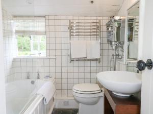 une salle de bain avec un lavabo, des toilettes et une baignoire dans l'établissement Gun Hill Cottage, à Horam 17 autres photos