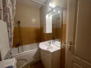 ein Badezimmer mit Waschbecken und Badewanne und Waschbecken in der Unterkunft INDI Apartman Siófok in Siófok + 13 Fotos