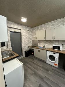 a kitchen with a washing machine and a sink at Room 1 in south Yorkshire in Sheffield