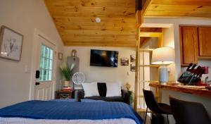 a bedroom with a bed with a blue comforter at Cheerful Cottage with Loft Close to Everything 6 in Edgecomb