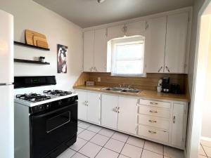 Del CityHome by Tinker/6 mi to Downtown OKC的厨房配有白色橱柜和黑炉灶烤箱。