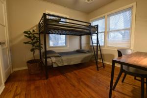 Del CityHome by Tinker/6 mi to Downtown OKC的一间卧室配有一张双层床、一张桌子和一张桌子。