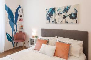 Un dormitorio con una cama con almohadas naranjas y blancas. en Vaticano Domvs - Appartamento ai Musei Vaticani, en Roma