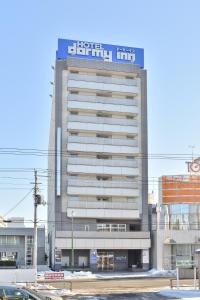 a building with a sign on the top of it at Dormy Inn Kitami in Kitami