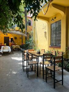 a table and chairs in front of a yellow building at Mar de Lava in Mexico City