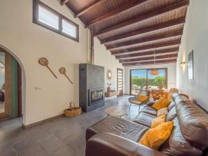 a living room with a leather couch and a fireplace at Villa Serena by 3VILLAS in S'Algar