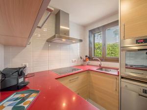 a red kitchen with a sink and a window at Villa Serena by 3VILLAS in S'Algar