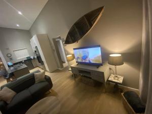 a living room with a couch and a television at Sunset at 30 Nivica Luxury Apartment in Langebaan