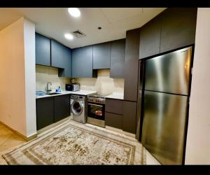 a kitchen with a stainless steel refrigerator and a dishwasher at Amman damac tower عبدلي عمان دماك Abdali Boulevard in Amman