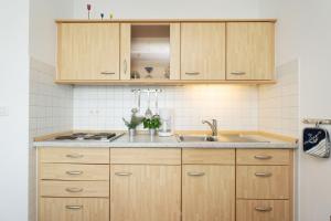 a kitchen with wooden cabinets and a sink at Am Südstrand 9 Strandburg II in Fehmarn