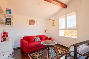 a living room with a red couch and a table at Regina's Banyuls - Town house close to beach in Banyuls-sur-Mer