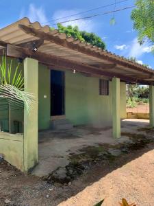 a small green house with a roof at Casa Jatobá in Abadiânia
