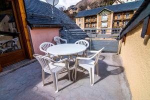 a white table and chairs on a balcony at La Biasou in Gèdre