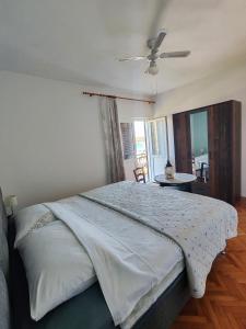 a bedroom with a large bed with a ceiling fan at Apartments Šimuni in Pag +38 photos