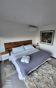 una camera da letto con un letto grande con due cuscini di Rapel Casa Lujosa piscina privada, acceso Lago a Lago Rapel Altre 32 foto