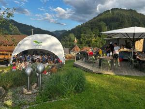 a group of people sitting in a tent in a yard at Campingplatz Schwarzwaldhorn in Simonswald