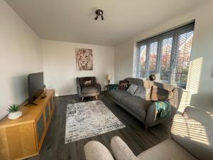 Down HatherleyにあるKale Drive House Long Stays Welcome Free Parking, Sleeps 6のソファとテレビのあるリビングルーム