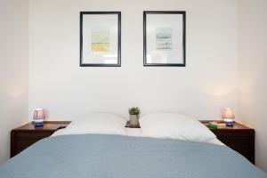 ein Schlafzimmer mit drei Bildern an der Wand mit einem Bett in der Unterkunft Berolina Panorama Dahme in Dahme