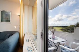 Zimmer mit einem Balkon mit einem Tisch und einem Sofa in der Unterkunft Berolina Panorama Dahme in Dahme + 29 Fotos