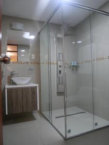 アレキパにあるHotel Santa Rosaのガラスのシャワーと洗面台を備えたバスルーム