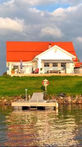 a house on the water with a dock in front at Northern Lights exclusive house by the river in Boden