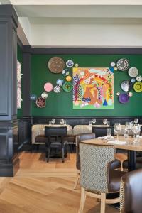a dining room with tables and plates on the wall at The Memphian a Tribute Portfolio Hotel in Memphis