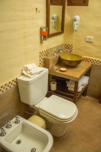 łazienka z białą toaletą i umywalką w obiekcie Gaia Suites Tilcara habitaciones temáticas w mieście Tilcara +95 zdjęć