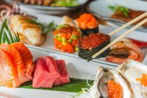 a plate of sushi with chopsticks and fruits and vegetables at Courtyard by Marriott Phuket Town in Phuket Town