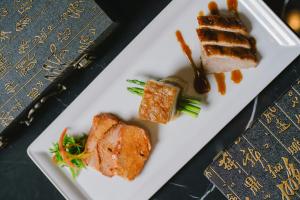a plate of food with meat and vegetables on a table at Courtyard by Marriott Phuket Town in Phuket Town