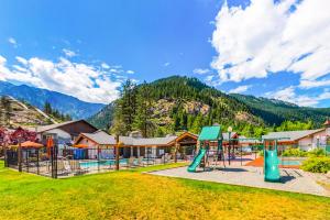 a playground in a park with mountains in the background at Dasha's alpine retreat at Icicle Village with pool and hot tub in Leavenworth