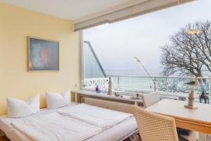 a dining room with a table and a large window at Hang 13 Wohnung 26 in Scharbeutz