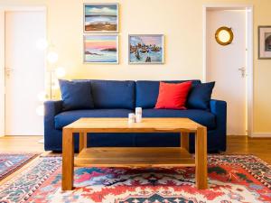 a blue couch with a wooden coffee table in a living room at Hang 13 Wohnung 26 in Scharbeutz
