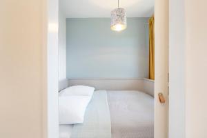 a small bedroom with a bed and a chandelier at Strandbungalow Ostsee in Rettin