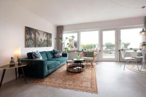 a living room with a green couch and a table at Strandbungalow Ostsee in Rettin