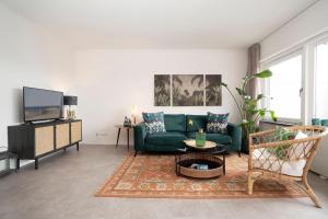 a living room with a green couch and a tv at Strandbungalow Ostsee in Rettin