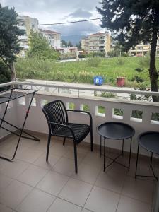 a balcony with two chairs and two tables and a view at Art decor luxury apartment in Komotini +9 photos