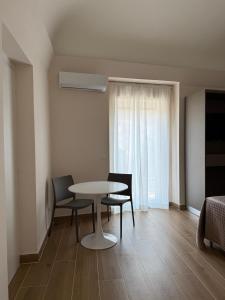a dining room with a table and chairs and a window at Umbrella House in Catania