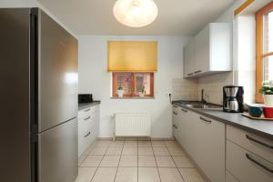 a kitchen with white cabinets and a window at ToHuus in Laboe