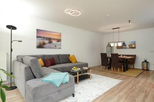 a living room with a couch and a dining room at ToHuus in Laboe
