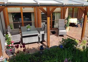 a patio with a table and chairs under a pergola at ToHuus in Laboe