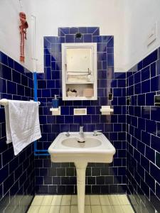 a blue tiled bathroom with a sink and a mirror at Mar de Lava in Mexico City