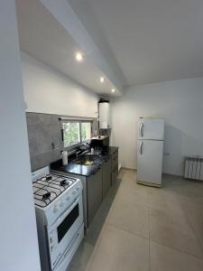 a kitchen with a stove and a refrigerator at Dpto Villa María - Excelente Estadía in Villa María +18 photos