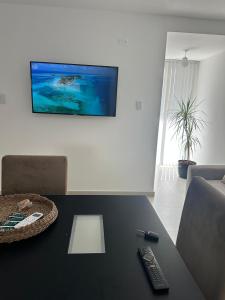 a living room with a table with a television on a wall at Dpto Villa María - Excelente Estadía in Villa María