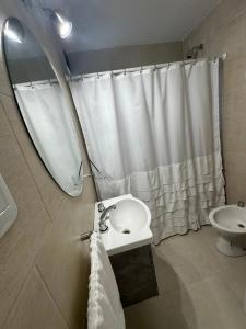 a bathroom with a sink and a toilet and a mirror at Dpto Villa María - Excelente Estadía in Villa María
